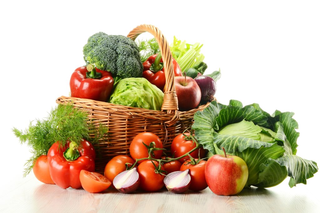 Vegetables in wicker basket isolated on white